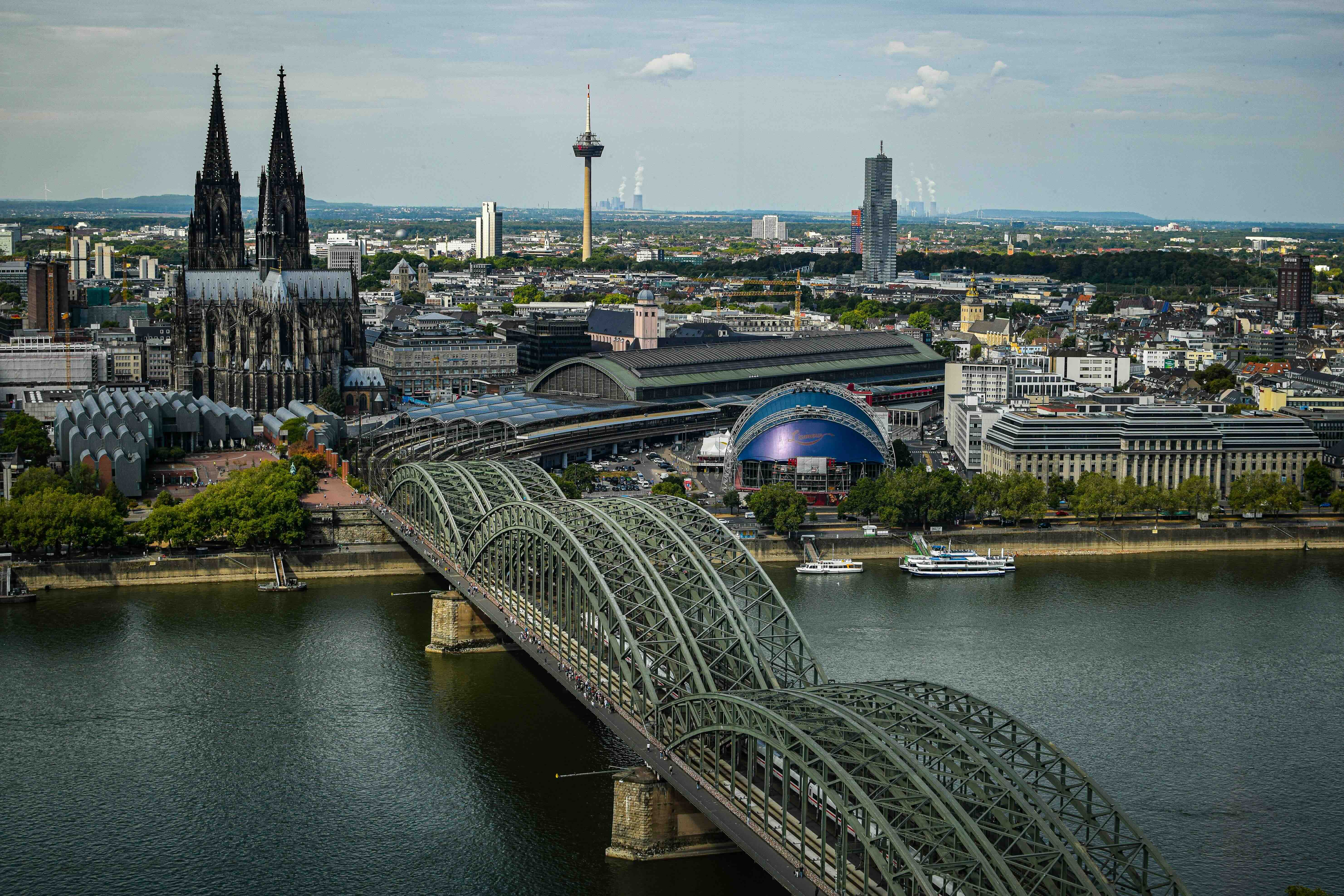 Cologne Cathedral and the Hohenzollern Bridge over the Rhine beside Kรถln Hauptbahnhof